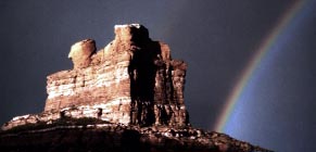 Colorado nature photography: ”Pot of Gold.”   Just another lousy day in paradise.  This image has served as my logo for years.  How wonderful to catch a view like this just 1/4 mile from home!   Photograph of Camel Rock / Chimney Rock, on the Wyoming border.  Click for a breathtaking close-up picture of Colorado at its best from Grabo', your one-man Colorado Chamber of Commerce!